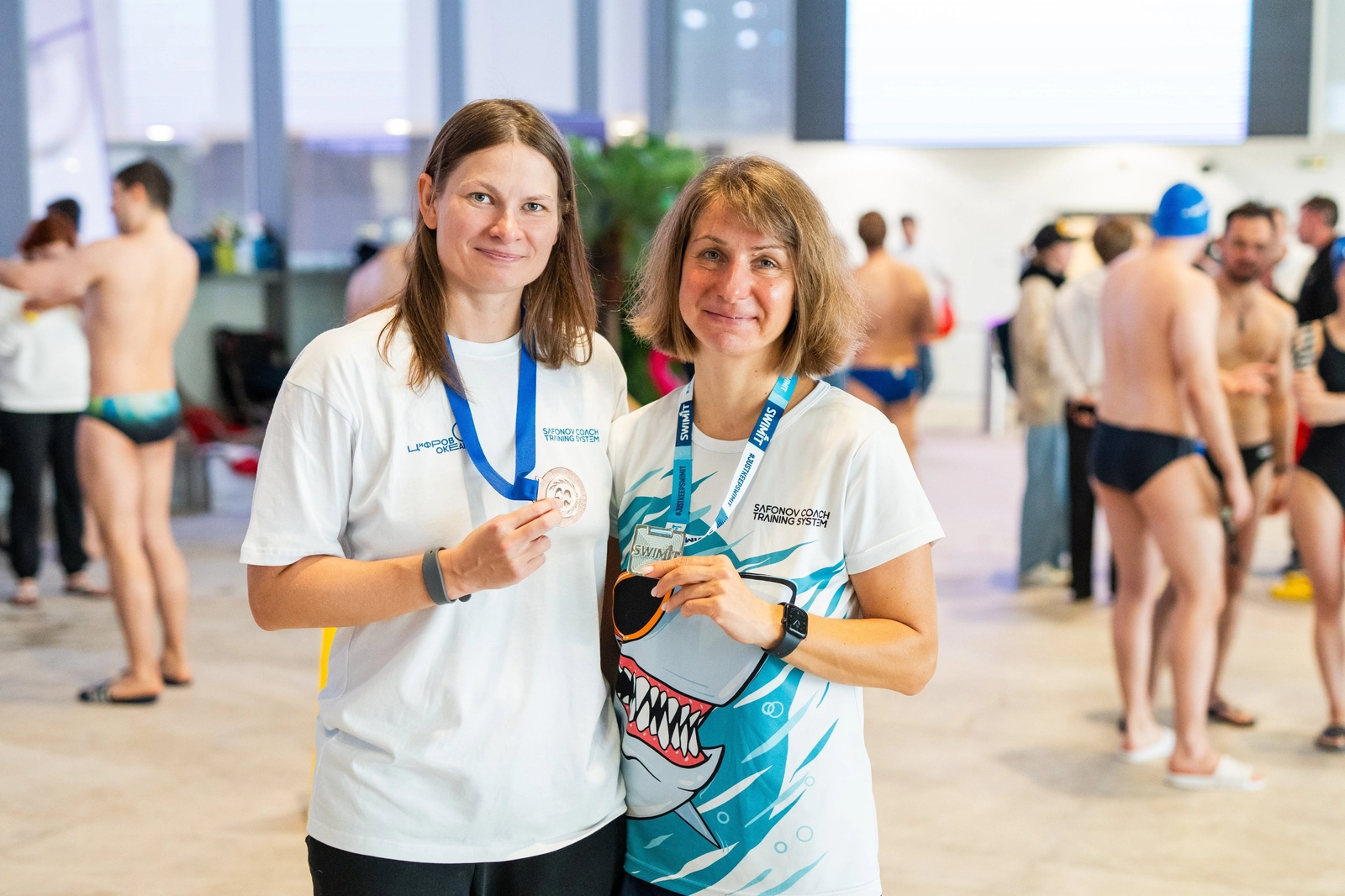 Две женщины в белых футболках с медалями